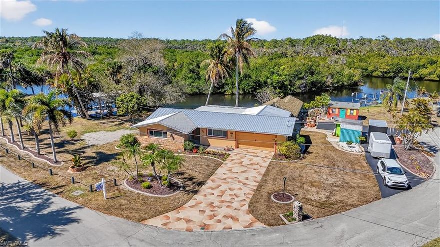 STUNNING-RIVER-ONE OF A KIND PRIVATE PENINSULA WATERFRONT (300+ FEET) HOME IS "PARADISE FOUND" WOW! FISHING, BOATING "SALT-LIFE" SO MANY INCREDIBLE THINGS WITH THIS BEAUTIFUL 3 BEDROOM, 2 BATH, 2 CAR GARAGE, COMPLETELY ($350,000+/-) REMODELED, RENOVATED AND NEW ADDITIONS ON A 1/2 ACRE OF WATER-FRONTAGE WITH INCREDIBLE "SUNSETS", DOLPHINS, MANATEES AND WILDLIFE RIGHT IN YOUR BACK YARD! Open floor plan with all 24"x24" ceramic "Marble Look" tile floors for easy maintenance. Volume ceiling with CROWN MOLDING ACCENTED FINISH. "CHEFS" Kitchen, ALL stainless steel appliances, level 5 granite tops, wood cabinets and Center Island work station and gathering point w/4 stool space.  ALL WINDOWS ARE NEW "IMPACT" STORM RESISTANT AND EVEN BETTER IS A NEWLY INSTALLED "STORM SURGE" PROTECTION & PREVENTION SYSTEM!- "THE CROWN JEWEL" Your very own Private, INCREDIBLE WATERFRONT "COMMERCIAL" GRADE 25'X36'X10' HUGE PARTY TIKKI-HUT (SEATING UP TO 24 FOLKS). IT WILL BE THE CENTER OF YOUR ENTERTAINING AND THE TALK OF ALL YOUR FRIENDS all in a-park-like setting. In Addition, it has a very rare own private BOAT RAMP and over 300' of BEAUTIFUL HANCOCK CREEK waterfront with FULL Gulf access. Located on Hancock Creek with great FISHING, BOATING, KAYAKING and quick access to the river and downtown Fort Myers by boat. Home has CITY WATER, Newer metal roof (2022), new air-conditioning, water heater, washer and dryer. "CAPTAINS" WALK DOCK with 10,000# LIFT AND PROTECTIVE CANOPY. There is plenty of extra storage with 3 SHEDS: THE HE-SHED, THE SHE-SHED AND THE WE-SHED. GOT AN RV, PLENTY OF STORAGE WITH 50 AMP SERVICE AND WATER. Cul-de-sac location makes it easy to back in or pull thru.  Most furnishings are negotiable. HOME COMES WITH ONE YEAR "HOME WARRANTY" FOR TOTAL BUYER COMFORT! THIS IS A "PREMIER GROUP" BEST VALUE WATERFRONT PROPERTY AND MUST BE SEEN IF YOU ARE A BOATER, R.V. OR NATURE LOVER!