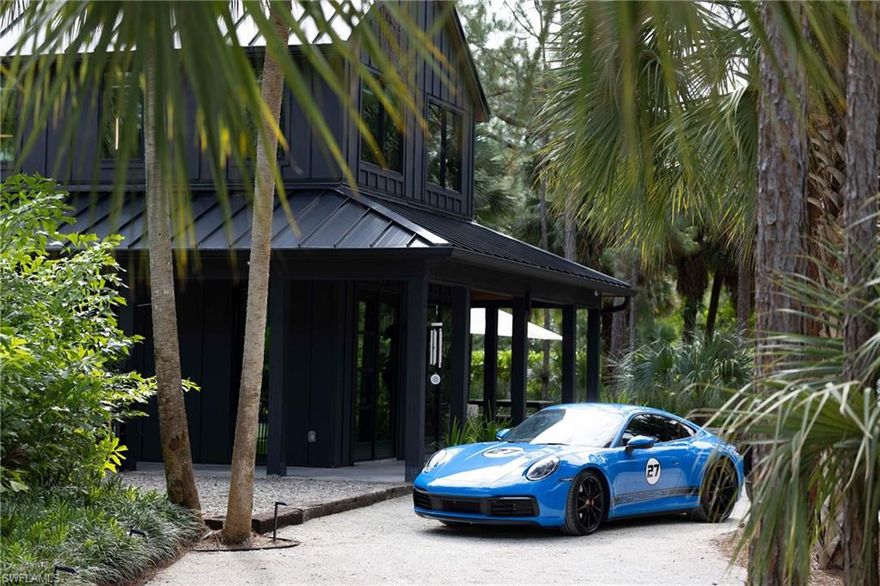 Naples Custom Masterpiece, where Luxury meets Design! This exceptional Naples residence (being offered turnkey) featured in Gulfshore Life’s 2022 Annual Home Edition and featured in various commercials, showcases the artful craftsmanship of custom furniture by a local designer. Every element reflects a deep connection to Florida’s authentic landscape, blending modern design, sustainability, and artisanal detail. The main home was designed with a focus on energy efficiency, the home features lcynene spray foam insulation, Andersen 400 Series low-E impact windows, and a standing seam metal roof. The open-concept layout enhances natural flow and light, with sugar pine interior walls, polished concrete floors, and custom steel-framed windows and doors offering timeless style. The gourmet kitchen is a showpiece of design and function, with solid walnut cabinetry, stainless steel accents, and high-end appliances including a Viking dual-fuel range, Dacor tower refrigerator, and Viking dishwasher. A striking walnut island and custom Guanacaste slab dining table complete the space. Two luxurious bathrooms feature floor-to-ceiling quartz slab showers, the downstairs bath with live-edge walnut and steel custom door and the second floor a sugar pine door, and TOTO washlets. Bedrooms include Pranasleep adjustable beds and custom-built furnishings. Upstairs, Legno Bastone oak flooring, custom cabinetry, and designer furnishings define the loft and office areas. Smart-home integration includes LED lighting, Sonos sound system, fiber optic connectivity, and comprehensive security cameras. Enjoy resort-style living in the luxurious outdoor spaces featuring a 12' x 75' two-lane lap pool and spa with detailed design, hydraulic solar-assisted cover, synthetic turf, and custom pergolas. Two fire pit areas, Sonos-integrated outdoor speakers, and the lush landscaping create a serene private retreat perfect for entertaining. The fully equipped 422 sq ft guest house offers a complete kitchen, laundry hookups, and the same impeccable finishes—sugar pine walls, concrete floors, and solid quartz walk-in shower. Ideal for guests, in-laws, or a private studio. Two carports, a climate-controlled 4,000 sq. ft. motor lounge with bay doors at both ends plus a second-floor cigar lounge and bar with floor to ceiling windows, a downstairs office space with kitchen and bath, plus additional storage containers and coop with hen house that can be converted to a dog kennel. Additional features include: 400-amp electrical service and solar-supported systems, soft-start HVAC system with linear vents, reverse osmosis water system with UV light, hardie board siding with custom cypress soffits and porch ceilings, fenced dog run and irrigation using well water for sustainability. This home is a true blend of artistry, functionality, and eco-conscious design — and embodies modern Naples living at its finest, with endless possibilities!