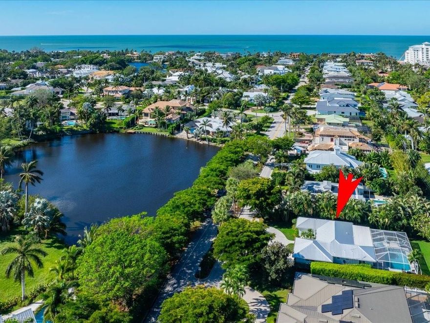 Ideally located on 7th Avenue North, directly across the street from stunning lake views, this exquisite Olde Naples home embodies coastal elegance and convenience. Offering three bedrooms, two baths, and easy walkability to the beach, this single-story residence is perfect for those seeking a serene yet vibrant lifestyle. As you enter, you'll be greeted by an abundance of natural light pouring through impact-resistant windows, illuminating the new luxury vinyl flooring that flows throughout the home. The updated landscaping and native Florida fauna enhance the property's curb appeal. The interior features include updated bathrooms and mud/utility room with ample storage adding to the home's functionality. Step outside to discover your private oasis including a fully fenced backyard with a dedicated dog run on the west side, ideal for your furry family members. The pool area boasts a newly laid shell stone marble deck, perfect for entertaining, alongside a spa and water feature that adds to the tranquil ambiance. The front porch invites you to relax and enjoy the picturesque North lake views, with no neighbors directly across the street ensuring your privacy and exclusive views. Additional highlights include a circle driveway for easy access and overflow guest parking, all impact windows and doors for added safety, and a third bedroom currently utilized as a den. Recent renovations include a brand new metal roof, fresh paint throughout, new cabinets and backsplash in the kitchen, new kitchen appliances (fridge, stove, hood, dishwasher), and a custom-built living room entertainment cabinet. This property is not only a beautiful home but also a potential investment opportunity, as it could serve as the ideal homesite for a new build or a comfortable residence until you are ready to build your dream home. With its prime location just three blocks to the beach and close to the new Four Seasons Resort, this Olde Naples gem offers the perfect blend of luxury and convenience. Furnishings are negotiable, making this an optimal opportunity for the discerning buyer.