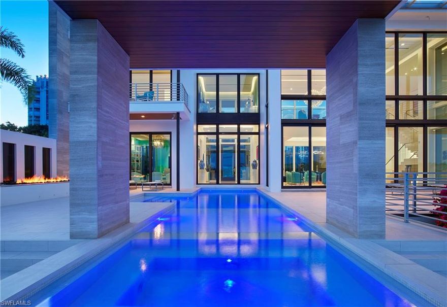 The jewel of Park Shore, this contemporary masterpiece hovers over the Venetian Bay like a diamond, taking advantage of every shimmering view.  The minimalist interior offers a monochromatic palette while featuring geometric architectural details and pops of cheerful colors, leaving you inspired. Walls of glass allow the views to seamlessly continue from room to room. The one of a kind outdoor living sprawls over the bay and provides many inviting spaces to enjoy the sun or relax in the shade near the summer kitchen. At dusk when the sun fades into the horizon, the sleek pool and outdoor fireplace looks like fire and ice giving off a mesmerizing glow.  The master suite is pure serenity with a private wrap around balcony for panoramic views, spacious bath with walk through shower and well thought out closets. Designed with the highest quality in mind, this John Cooney concept was constructed by BCB and built to stand the test of time, sitting atop of 90ft pilings and formed with over 1,000 tons of concrete. Complete with generator, 3 car garage, Crestron automation, underwater lights, elevator and entry gate for security, this is the opportunity to own an iconic part of Park Shore.