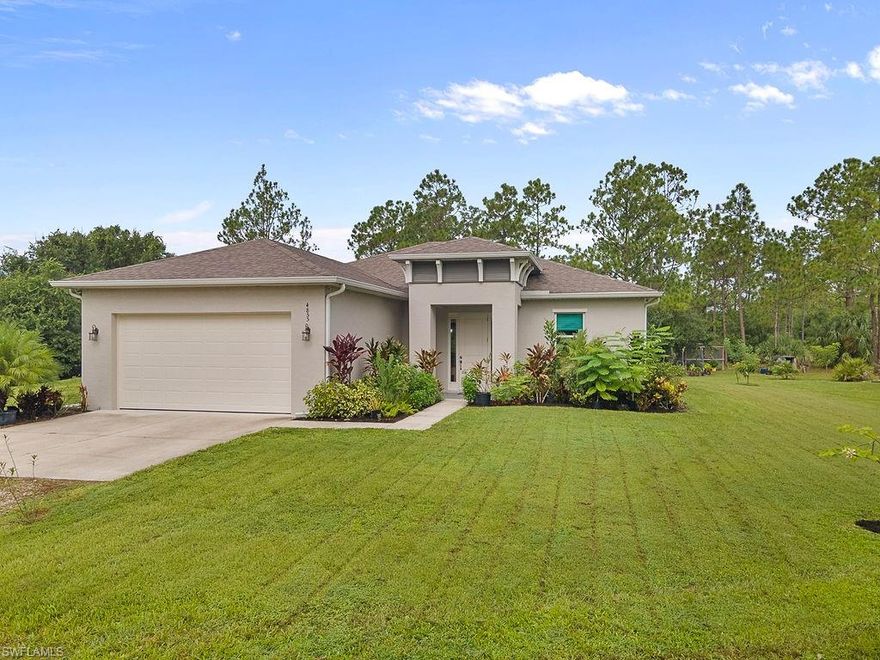 Built in 2023, this stunning 3-bedroom plus den home with a 2-car garage is tucked away on 2.27 acres (no wetlands) at the end of a quiet dead-end street in the desirable NE section of Golden Gate Estates in Naples, Florida, offering peace, privacy, and no traffic noise. Full of soothing color tones and warm wood accents, the home exudes a comfortable, cozy feeling while still offering modern elegance. Thoughtfully upgraded throughout, it features solid wood maple 41” cabinetry, quartz countertops, upgraded stainless steel Samsung appliances with drawer microwave and hood system, French doors to the den, frameless shower glass in the primary bathroom, an expanded primary closet, and smart design touches like a 40-amp outlet for EV charging, epoxy-coated garage floor, CAT5e wiring to every room, a whole-home surge protector, and a monthly serviced whole home reverse osmosis water system. Outdoor enhancements include gutters around the entire home, plumbing for a future outdoor kitchen, over 15 young fruit trees, a 320 sq ft storage container, and an expanded roundabout driveway. The property also carries a structural warranty through 2033. Ideally located just 15 minutes to Palmetto Ridge High School, Corkscrew Middle School, the new Publix shopping center with dining and retail, and Corkscrew Swamp Sanctuary where you can stroll through nature and wildlife, plus only 20 minutes to Seminole Casino, this home offers both modern comfort and the serenity of estate living.