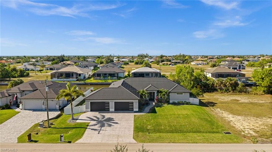 This exceptional waterfront residence offers refined coastal living with direct Gulf access and no bridges, ideal for boating enthusiasts. Built in 2021, this 4-bedroom, 4-bath home with a dedicated, separate office spans 3,370 sq ft and sits on a fully fenced triple lot, delivering privacy, space, and modern design. The property features a 16,000-lb boat lift and expansive canal views. Western exposure provides unforgettable sunset views from the resort-style outdoor living area featuring a heated saltwater pool and spa with a fully equipped outdoor kitchen. Inside, the home showcases a designer kitchen with a large quartz island, impact windows and doors, and advanced whole-house air quality systems including fresh-air dehumidification, HEPA bypass filtration, and REME HALO UV technology. A spacious 4-car garage includes a mini-split A/C and heat, offering flexibility for storage, workshop use, or a future car lift. Transferable flood insurance under $800/year.