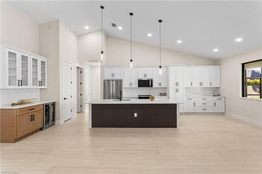 Stop & behold! Move-in-ready NEW CONSTRUCTION HOME - 2026 - complete w/ 2-10 HOME WARRANTY! Located in desirable NORTHERN SW Cape Coral, offers NO FLOOD INSURANCE, durable METAL ROOF, 3-CAR GARAGE & CITY WATER & SEWER! $1,800-$2,400/year homeowners' insurance! Enjoy easy access to CHIQUITA BLVD & PINE ISLAND RD, making commuting & daily errands easier! Designed for MODERN FLORIDA LIVING, this CONTEMPORARY LUXURY HOME features SCREENED, HEATED POOL & SPA, perfect for year-round enjoyment! With 4 BEDS & 3 full BATHS, the layout is ideal for EVERYDAY LIVING & ENTERTAINING! SCREENED LANAI provides PERFECT SETTING TO RELAX in SPA, SWIM in HEATED POOL, or HOST UNFORGETTABLE BBQs while enjoying THE BEST OF SWFL LIVING! Bright, open layout w/ LIGHT NEUTRAL TILE FLOORING throughout. IMPACT-RESISTANT DOUBLE DOORS lead into WELCOMING LIVING ROOM w/ 12-ft VAULTED CEILING & SLIDING DOORS TO LANAI. GORGEOUS CHEF'S KITCHEN w/ SPACIOUS QUARTS COUNTERTOP ISLAND w/ undermount LARGE SINK & SLEEK MATTE-BLACK gooseneck FAUCET. Crisp WHITE SHAKER CABINETRY is paired w/ contrasting warm WOOD-TONE ISLAND CABINETS & modern BLACK HARDWARE for a sophisticated coastal-modern design. Equipped w/ SS appliances, French-door refrigerator, microwave, smooth-top range & dishwasher. Elegant pendant lighting & recessed ceiling lights illuminate OPEN-CONCEPT SPACE, while GLASS-FRONT UPPER CABINETS add touch of ELEGANCE & DISPLAY STORAGE. Built-in BUTLER'S PANTRY w/ quartz countertop, glass-front cabinetry, warm wood base cabinets & WINE REFRIGERATOR, ideal for BEVERAGE STATION, COFFEE BAR, or EXTRA STORAGE & PREP SPACE. DINING ROOM features bright, modern design, neutral tones & vaulted ceiling w/ recessed lighting that enhances the open feel. LARGE PICTURE WINDOW brings in natural light & offers views of screened lanai & backyard. BUILT-IN CUSTOM WHITE CABINETRY provides ADDED STORAGE & CLEAN, UPSCALE LOOK. LARGE PRIMARY SUITE w/ sliding doors to lanai, WALK-IN CLOSET w/ BUILT-IN SHELVING & HANGING RACKS & LUXURIOUS PRIMARY BATHROOM w/ spacious WALK-IN GLASS SHOWER w/ floor-to-ceiling designer tile, rainfall showerhead, built-in bench & modern matte-black fixtures. Dual-sink vanity w/ quartz countertops, sleek white cabinetry & contemporary lighting complements the spa-like design. Private water closet & generous natural light create BRIGHT & SERENE RETREAT! SPLIT LAYOUT offers SECOND PRIMARY SUITE w/ POOL BATHROOM & TWO GUEST BEDROOMS w/ HALL BATHROOM for added privacy. Step outside to SCREENED LANAI w/ HEATED POOL & SPA, landscaped surrounding & FULLY EQUIPED OUTDOOR KITCHEN w/ BUILT-IN stainless steel BBQ GRILL, SINK, BEVERAGE REFRIGERATOR, GRANITE COUNTERTOPS & MODERN BACKSPLASH, ideal for OUTDOOR DINING & ENTERTAINING! PAVER FLOORING & CEILING FAN create COMFORTABLE SPACE for YEAR-ROUND ENJOYMENT. LAUNDRY, 3-CAR GARAGE & long-lasting METAL ROOF complete HOMES' FUNCTIONAL FEATURES. Experience SWFL lifestyle, SCHEDULE YOUR PRIVATE SHOWING TODAY & discover YOUR PIECE OF PARADISE!