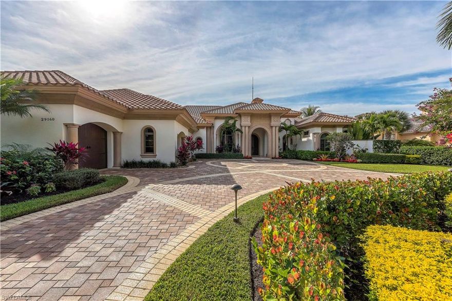 Long shimmering lake and Golf Course views. Custom appointments and distinctive architectural features found throughout include volume ceilings, crown moldings, wide floor moldings, extensive windows, custom faux finishes, architectural niches, arched passageways, custom carpet, natural stone flooring and custom bar. Gather around the gas fireplace alongside the summer kitchen boasting a gas built in grill, and under counter refrigerator. Beautiful negative edge shimmering pool and cascading spill over spa surrounded by professional landscaping.  Generator and custom Wine Cellar.