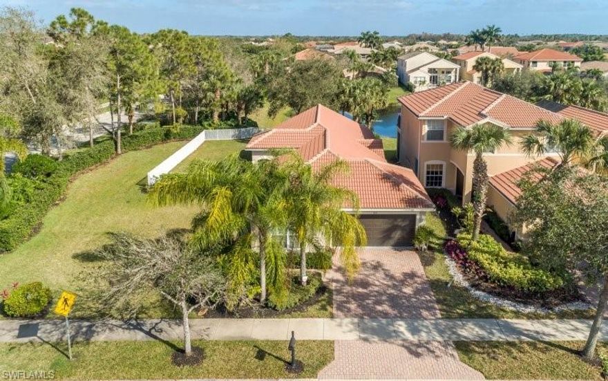 This pristine "Cortina" is situated on an oversized lot. It’s vast great room has vaulted ceilings and recessed lighting. Neutral tile is laid on a diagonal pattern throughout the main living areas. Plank tiles laid bedrooms. The spacious master suite has a tray ceiling, a beautiful lake view and a large walk-in closet. Kitchen includes GE stainless steel appliances, granite countertops and backsplash, under cabinet lighting, a pantry, and a breakfast cafe. The private backyard is surrounded by a fence, overlooks a lake and has accent spot lights on the trees. Clean paint, updated lights/ fans, hardware, a new A/C unit installed in 2018, 2 car garage with epoxy flooring and a laundry room. Newly remodeled "Club at Saturnia Grande" offers resort pool, lap pool, kiddie pool, hot tub, saunas, fitness center, dance studio, billiards room, grand ball room, 4 Har-Tru lighted tennis courts, basketball court, putting green and more! HOA fees include landscaping, irrigation, clubhouse amenities, alarm monitoring, premium cable TV, High Speed Internet (Fiber Optics), and phone. Saturnia Lakes is one of Naples top gated single family communities in A rated schools close to beaches, I-75.