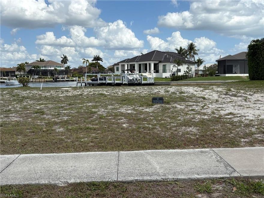 Canal front lot to build your dream home on Marco Island. Photo shows two lots. 137 is the one on the right the bush at the back with the red marking is the property line.