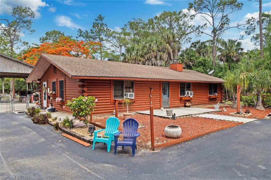 Experience the rare combination of 2.28 acres on a freshwater canal, gated and fully fenced privacy, mature tropical landscaping, a character-filled log-style home, and a massive 40x40 hangar/workshop, all in a prime Naples location close to shopping, dining, and everyday conveniences.

The rustic 4-bedroom, 2-bath home is surrounded by towering pines, mature palms, vibrant flowering trees, and peaceful natural scenery that create a true country-style atmosphere. The impressive concrete hangar/workshop includes electric, lighting, water, approximately 12-foot height clearance, and additional room space—ideal for storage, hobbies, recreational vehicles, boats, equipment, or a home-based workspace.

With expansive open space, lush landscaping, waterfront views, and endless potential, properties like this rarely become available in Naples. Property is being sold AS-IS.