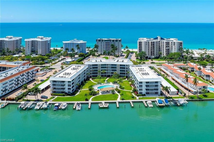 Positioned just steps from the beaches of Naples, this turnkey furnished residence offers a rare combination of coastal proximity and thoughtful interior renovation. Extensively updated in 2023, the property reflects a refined approach to design, functionality and long-term livability.  Impact-resistant windows and continuous luxury vinyl plank flooring establish a cohesive interior, complemented by a neutral palette suited to a range of design preferences. The kitchen has been re-envisioned with quartz surfaces, stainless steel appliances and a glass tile backsplash, anchored by a streamlined stainless steel ventilation hood designed for both efficiency and visual continuity.  Both baths feature updated tilework, glass-enclosed showers and well-proportioned storage, creating a consistent aesthetic throughout the residence.  A distinguishing element of this property is the presence of two private rear entrances with direct access from the covered carport, offering a level of convenience and separation not commonly found within the community.