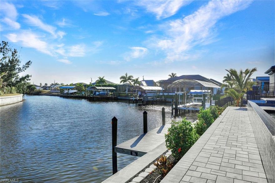 Direct Gulf Access with panoramic intersecting canal views, southern exposure, and LOADED WITH UPGRADES. This custom-built NEW CONSTRUCTION home is completed and move-in ready, offering 3 beds plus an office, 3 full baths, a 3-car garage, and an oversized lot positioned on a wide intersecting Gulf access canal. The negative edge pool and spa overlook expansive water views, while the sunny southern exposure provides the most daytime sunlight on the pool area. Designed for true indoor-outdoor living, the home features 90-degree sliding glass doors that open completely to the lanai, blending interior & exterior spaces. Inside, you will find tile flooring laid in a herringbone pattern, soaring volume and tray ceilings, a open great room concept, and motorized blinds. The chef’s kitchen is built to impress with a 6-burner gas range, dual wall ovens with convection, air fry, and steam features, a French 4-door fridge, a pot filler, under-cabinet lighting, an oversized center island, a walk-in pantry, and a waterfront dining space. A large built-in bar with a wine cooler provides an elegant entertaining area or coffee station. The home includes a full-house RO (reverse osmosis) for great water. The home is wired for indoor surround sound and features outdoor speakers ideal for entertaining, poolside gatherings, and watching the big game! The master suite is a waterfront retreat with dual walk-in closets and a spa-inspired bath featuring LED mirrors, a designer soaking tub, dual vanities, and a custom walk-in shower with striking tile detail. Guest bedrooms are generously sized and thoughtfully appointed for family and visitors.
The heated saltwater pool and integrated spa include water features and a summer kitchen with built in grill and bar seating. Step down to the brick paver captain’s walk and private dock, perfect for sunbathing waterside, fishing, or launching your boat directly from your backyard. Enjoy direct access through Matlacha Pass to the Gulf of America, Sanibel, Captiva, Cayo Costa, white sand beaches, waterfront restaurants, and world-class fishing with no bridges, no locks, and no restrictions. Built for durability and peace of mind, the home sits one block higher for added elevation, features a metal roof, PGT impact windows and doors, a 500-gallon propane tank servicing the kitchen and outdoor grill, and is wired for a permanent or portable generator. Located near Palmetto Pines Country Club and Coral Oaks Golf Course, and just minutes from Target, Publix, Starbucks, parks, and top-rated restaurants. The nearby Seven Islands Project and Cape Coral Grove are poised to transform the area with new marinas, boutique shopping, dining, green space, and mixed-use development projected to generate significant economic growth. This is luxury Gulf access living with intersecting canal views, southern exposure, new construction quality, and long-term waterfront upside in one of Southwest Florida’s fastest-growing boating corridors.