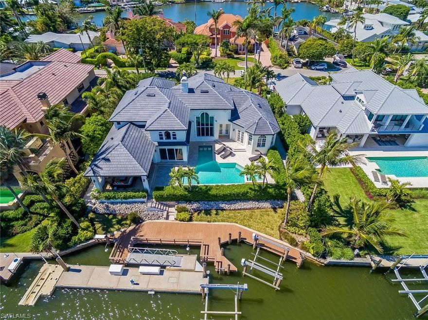 CALLING ALL SERIOUS BOATERS! Widest canal (over 200') in Aqualane Shores with no bridges and only a few minutes to Naples Bay & the Gulf PLUS only 1 block to 3rd St S and 4 blocks to the beach. Composite wood deck runs the full width of lot, there is a 50' floating dock, 2 boat lifts (7K & 16K lbs) + jet ski dock, electric & water & fish cleaning station. This 4 bedroom home with 3 car garage also features his and hers study's and has a brand new roof, new paint inside and out as well as impact windows & doors. Other features include electric screens for the outdoor living area with TV, fireplace & grill. So many extras inside too!  Master & 1 guest suite on the first floor. 2nd family room and 2 more ensuite bedrooms upstairs. Wine storage and wet bar, walk-in pantry and plenty of cabinetry and storage. Whole house audio with speakers in each room. This highly desirable lot/location/home is one of the best values in Aqualane - come see for yourself!