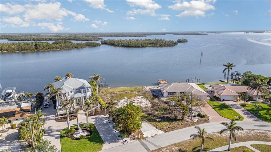 STUNNING & EXPANSIVE unobstructed BAY & WATERFRONT VIEWS across Estero Bay Aquatic Preserve from this OVERSIZED cleared and buildable BAY FRONT lot! Over 100' of spectacular water frontage on over 1/3 of an acre which wakes up to beautiful sunrises across the bay and is only a short distance to Deeded Beach Access &  sunsets on the Gulf! One of the most sought after waterfront and boating communities on the island, Holiday Heights, is known for it's higher elevation, gulf access canals and warm & friendly community. Build your custom designed dream home on this oversized bay front lot offering awe inspiring views and the best in coastal living! Located mid-island close to Publix grocery store, trolley stop, full service marina, Fresh Catch Exquisite Waterfront Dining & Junkanoo Below Deck for the more casual waterfront dining experience. Don't miss out on this opportunity to own one of the few vacant bay front lots in this desirable mid island neighborhood location!