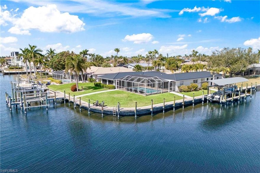 RARE DIRECT GULF ACCESS opportunity in the highly desirable Yacht Club area — a waterfront property that rarely becomes available. Situated on a cul-de-sac on an oversized corner lot with approximately 230 feet of seawall and wide intersecting canal views, this location offers seconds to open water with no bridges, making it a true boater’s dream and million-plus-dollar homesite on its own. The waterfront setup is exceptional, featuring three boat lifts (one with canopy), captain’s walks, wiring, and composite decking along the seawall for secure access. Launch within moments to the Caloosahatchee River, Gulf of Mexico, Sanibel, Captiva, and Fort Myers Beach, with waterfront dining and marinas minutes away.

This property has been extensively upgraded and meticulously maintained, offering confidence and long-term value. Major improvements include a 50-year roof (2023), pool resurfacing and new pool deck/lanai (2022), paver driveway and walkways (2025), updated pool equipment including a Pentair pool pump (2024), pool heater (2025), and Pentair saltwater chlorinator (2025). The home also features two Rollingshield motorized screens (2022), a pool cage screen (2022), and professional mold remediation following Hurricane Ian.

Inside, the home was fully remodeled with high-end finishes throughout. A Kraftmaid kitchen (2023) anchors the interior, complemented by Frigidaire Professional appliances, side-by-side refrigerator/full freezer, and an Apec reverse osmosis system. Additional upgrades include an LG Washtower (2022), garage AC compressor (2024), and updated systems. Offered fully furnished (with a few exclusions), the home showcases tasteful coastal décor with custom cabinetry, gold hardware, upgraded lighting, flooring, and curated finishes that create a polished aesthetic.

The interior is bright and welcoming, with comfortable living spaces designed for everyday living and entertaining. The kitchen flows seamlessly into the dining and living areas, ideal for hosting or relaxing after a day on the water.

Outdoor living is exceptional. The heated saltwater pool and expansive screened lanai create a resort-style setting for hosting, relaxing, and enjoying panoramic intersecting canal views — fully capturing the Southwest Florida waterfront lifestyle.

The 2-car air-conditioned garage/man cave features glass sliding doors providing immediate access to your boat just steps away. Whether used as a primary residence, seasonal escape, or high-income vacation rental, the combination of direct Gulf access, 230 feet of seawall, multiple boat lifts, recent upgrades, premium remodeling, and furnished move-in-ready convenience makes this an extraordinary offering in one of Cape Coral’s most sought-after boating locations.