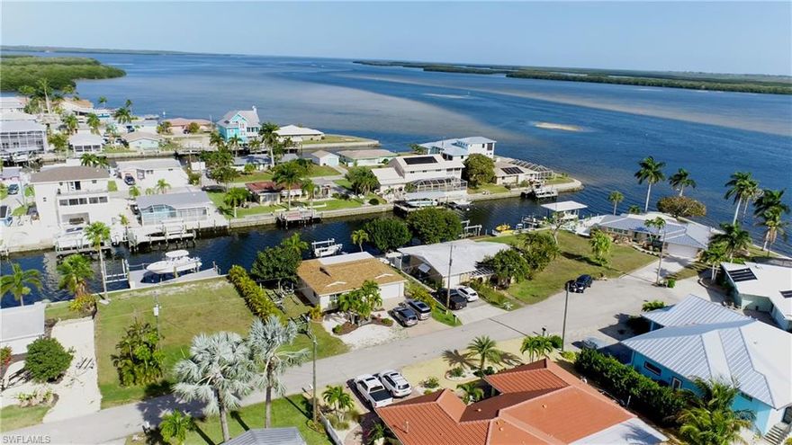 Turnkey Matlacha home on an oversized Lot! This spacious 2 bedroom 2 full bath home is fully furnished with modern coastal decor, is turnkey ready and sits on an oversized lot with 70 ft of frontage! The location of this property has lots to offer! This perfect island getaway is within walking distance to the heart of the funky coastal village of Matlacha featuring unique art galleries, live entertainment, local restaurants and boutiques for fun on land! For fun on the water, Matlacha is surrounded by some of the best fishing in the world, beautiful native wildlife, kayak trails and pristine white sand beaches of the Gulf of Mexico. This home offers an open floor plan with with spacious bedrooms. The outdoor living space really sets this home apart featuring a huge screened  porch ideal for taking in the famous Matlacha sunsets! Home is completely turn key and is currently being used as a very profitable vacation rental with bookings into 2024. Some of the other outstanding attributes include, 2020 roof, new 10k boat lift, composite dock and tile throughout and plenty of room for a pool! Come see this island home today and start Living the Island Life!