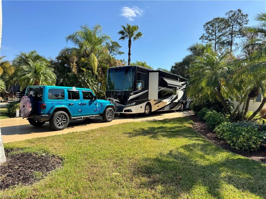 There’s something about Lot 186 that just feels easy the moment you arrive. Maybe it’s the way it’s tucked into such a friendly little pocket of neighbors or maybe it’s the fact that you’re just steps from the pool, yet still perfectly positioned to enjoy your own peaceful retreat inside RiverBend Motorcoach Resort. This beautiful back-in lot was made for connection and comfort. The raised patio area becomes the heart of the property, the kind of place where evenings naturally turn into laughter-filled gatherings. Friends pull up the bar stools at the outdoor grill and patio bar, whip up a tray of hors d’oeuvres, and just like that, it’s another perfect night under the palms. During the day, the patio offers plenty of room to stretch out and relax. Morning coffee tastes better out here. Afternoon breezes seem softer. There’s space for all your outdoor furniture, and then some. The landscaping is lush and tropical, with seasonal pops of colorful plants thoughtfully added to keep that fresh, vibrant Florida feel all year long. Step into the coach house and you’ll immediately notice how light and welcoming it feels. A soft, neutral interior keeps everything bright and timeless. Tile flooring, a ceiling fan, and a dedicated AC unit ensure comfort in every season. There’s also a mini fridge and washer-dryer, because convenience matters when you’re living the good life. The bathroom is a sweet surprise, offering just the right hint of coastal charm. A lovely shower, blinds on every window, and glass French doors with built-in blinds complete the space beautifully. And the location? Truly ideal. Just a short stroll to the clubhouse or pool, making it effortless to jump into the fun or take a refreshing dip whenever the mood strikes. Even better, outdoor furniture conveys with the purchase, along with select interior pieces, making this feel almost turnkey and ready to enjoy from day one. When it’s time to socialize, head down to one of our clubhouses. Yes, we have three! Whether you choose poolside afternoons at the cabana bar, refreshing swims in the resort-style pool, relaxing soaks in the hot tubs, or riverside evenings filled with live music and themed dinners, there’s always something happening. Feeling adventurous? Jump into trivia night, gather for bocce, try Zumba or line dancing, test your poker face at Texas Hold-Em, and so much more. The lifestyle here is active, welcoming, and full of energy, and you can be as social (or as relaxed) as you’d like. That’s the beauty of it. Pull in, plug in, and let the fun begin at RiverBend Motorcoach Resort.