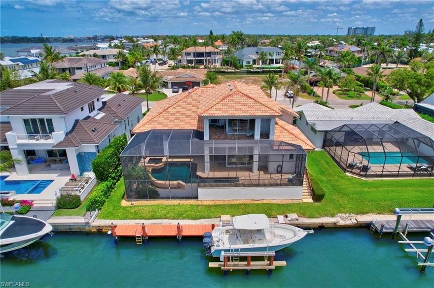 Situated on a quiet street in the heart of Royal Harbor, this premium waterfront residence offers over 4,100 square feet of thoughtfully designed living space and exceptional outdoor amenities. Enjoy southern rear exposure with tranquil canal views from the black-bottom infinity-edge pool, overlooking the private dock and deep-water canal. Designed for effortless indoor-outdoor living, the expansive screened lanai spans the length of the home and includes an outdoor kitchen—ideal for entertaining or relaxing dockside.
The home features desirable first-floor living with the added flexibility of a spacious second level. The main level includes multiple generous living areas, a large primary suite, two additional ensuite bedrooms, a study, formal and informal dining areas, a well-appointed kitchen, powder room, and laundry. Upstairs, a versatile bonus level is perfectly suited as a private guest retreat, offering a large bedroom, full bath, oversized bonus room, and balcony with bay views.
Boaters will appreciate the 13,000-lb boat lift and quick Gulf access via Gordon Pass in approximately 12 minutes. With a base floor elevation of 10 feet, the home has never experienced interior flood water. Royal Harbor’s prime location places residents just minutes from downtown Naples, white-sand beaches, the Bay Shore Arts District, Baker Park, the Botanical Gardens, and everyday shopping and dining.
Well maintained and priced to sell, this waterfront home is ready for a new owner to add personal touches and enjoy the best of the Naples boating lifestyle.