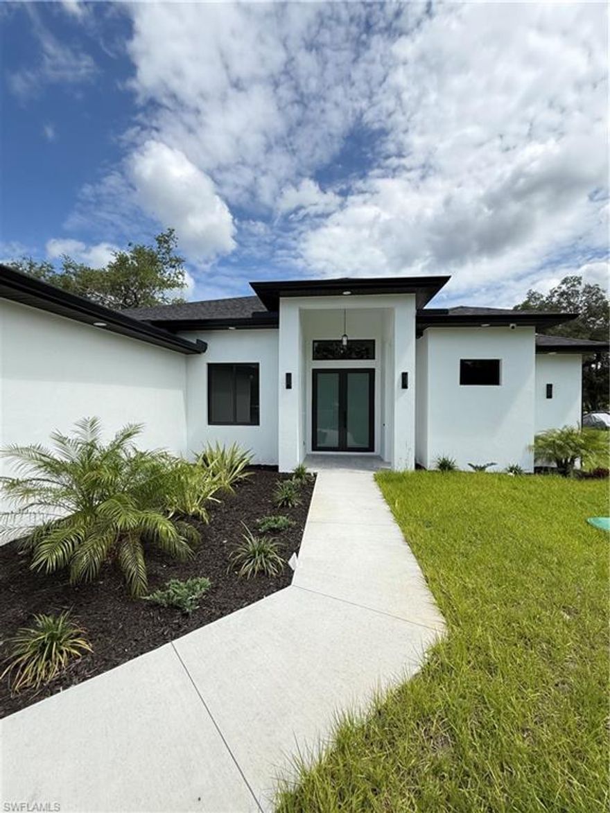 Beautiful New Construction Home located in Naples Estates! This modern residence features an open-concept design with high-end finishes throughout. The kitchen offers sleek cabinetry, quartz countertops, and built-in appliances. Enjoy outdoor living with a  outdoor summer kitchen, perfect for entertaining. Spacious and private setting with no HOA restrictions.