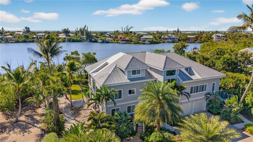 This is the kind of property that reminds you of why you moved to the island.
Tucked away at the end of a quiet sandy road, this exceptional waterfront retreat sits on Dinkin’s Bayou and delivers the full Sanibel boating lifestyle. Nearly 3,000 square feet of thoughtfully designed living space is surrounded by lush tropical landscaping, creating privacy, serenity, and nonstop water views.
The main living level is bright, open, and designed to capture the bayou at every turn. Walls of glass frame the water, while engineered hardwood floors and clean coastal finishes keep the space airy and inviting. The living, dining, and kitchen areas flow seamlessly together and open directly to the expansive screened lanai, where the heated pool overlooks the bayou. Sunrise coffee and sunset cocktails are both non-negotiable here.
The kitchen is efficient and stylish with ample cabinetry, stainless appliances, and easy sightlines to the water and living areas. Entertaining feels effortless and everyday living feels relaxed.
The primary suite is a true retreat with peaceful water views, a custom walk-in closet, and a well-appointed bath. Additional guest bedrooms are thoughtfully placed to provide privacy and flexibility, including space that works beautifully for visiting family or extended stays.
A private elevator connects all levels, because carrying groceries upstairs is overrated. A dedicated office provides a quiet workspace when duty calls, and generous storage areas throughout the home keep everything organized and out of sight.
Outside is where this property truly flexes. Two private docks with electric and water, a 10,000-pound boat lift, and a 7,000-pound boat lift provide quick Gulf access and room for multiple water toys. Wildlife sightings are part of the daily routine, and the bayou setting delivers calm waters with big island character.
This is not just a home. It is a front row seat to the Sanibel lifestyle. Quiet, coastal, and unapologetically waterfront.