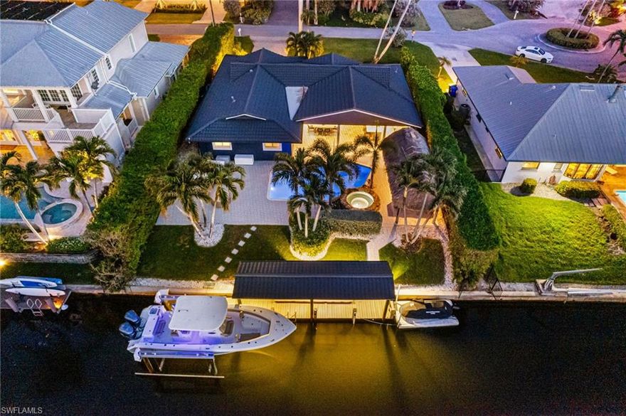 RARE INTERCOASTAL LOCATION & UPGRADES GALORE! This sought after Boater's LUXURY Paradise has been COMPLETELY REIMAGINED with a FULL REMODEL top to bottom including a UNIQUE NEW metal Worthouse roofing, soffit & gutter system highlighted by a complimentary wood plank lanai ceiling and wood soffits that elevate the curb appeal to a new level. Experience true Florida living with this exceptional waterfront home, offering direct Gulf access with no bridges and a grandfathered covered Boathouse w/12,500 lb. boat lift & floating jet ski dock —- a rare & valuable feature in this prominent Location!  The light, bright and open floorplan home has been meticulously renovated to designer perfection. The expansive chef's kitchen boasts the upgraded Cafe appliance Package in Matte White with Brushed Bronze Hardware and designer black range hood, all complemented by an oversized Quartz waterfall island that serves as a striking, modern centerpiece and elegantly weighted by the contrast base cabinet paneling. Custom designer lighting, fans, faucets, hardwear & mirrors throughout the property elevate its luxurious feel. DETAILS, DETAILS, DETAILS - upgraded modern shaker doors and molding feel like new construction highlighted by plantation shutters and electric front door shade contrasted by gorgeous white oak LVP flooring throughout. Uniquely designed modern custom tile in each of 3 bathrooms. NEW Custom Closet systems maximize organization throughout. This home seamlessly combines elegance, functionality, AND security w/all new impact windows and doors.  And there is MORE!   Step out onto an expansive lanai that seamlessly blends indoor and outdoor living, complete with a sparkling pool and spa with rock waterfall water feature overlooking a serene 60-foot-wide canal. This property is an entertainer's dream, boasting a large chickee hut perfect for lounge seating or a large game table AND a full outdoor kitchen complete with a large island. Enjoy top-tier amenities, including a Lynx hooded grill, Primo hooded grill and smoker, an outdoor beverage fridge and a built-in sink—all thoughtfully designed for hosting unforgettable gatherings under the expanded shaded roof covering. This is your opportunity to embrace the ultimate waterfront NAPLES lifestyle!
*** NO Milton or Helene damage.