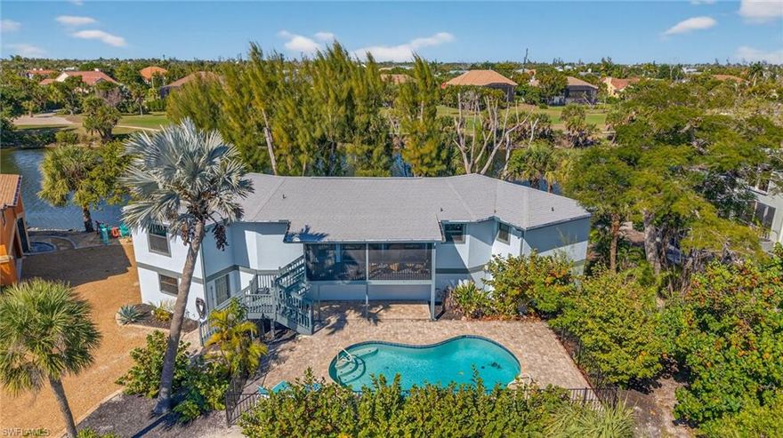 Completely reimagined and thoughtfully redesigned, this Sanibel home blends refined style with relaxed coastal living. At its heart is a showstopping kitchen designed by a professional chef to serve as both a high-functioning culinary workspace and a natural gathering hub. The expansive 16-foot island, illuminated by Restoration Hardware pendants, invites conversation and lingering evenings, perfect for beautifully arranged hors d’oeuvres and a glass of wine with friends. Natural, one-of-a-kind quartzite countertops add luxurious texture and durability, while Jenn Air appliances — including a sleek induction cooktop — deliver elevated performance. A beverage station and coffee bar with glass-front cabinetry, LED lighting, and a built-in wine cooler add both sophistication and convenience. The efficient work triangle ensures cooking is as enjoyable as dining. Wide-plank luxury vinyl flooring runs continuously throughout, intentionally installed without threshold breaks to create a clean, expansive feel. Vaulted ceilings in the great room enhance the sense of openness, while energy-efficient LED puck lighting provides a warm, modern glow. New interior doors and refined trim details complete the home’s crisp, updated finish. A dramatic wall of new impact-rated sliding glass doors frames one of the most captivating views on the island. The Sanibel River shimmers with mangroves and vibrant wildlife, while beyond it the rolling emerald fairways of multiple holes at the Sanibel Island Golf Club create a rare and picturesque backdrop. Subtle glimpses of the Gulf remind you just how close the shoreline is. The reimagined primary suite is a private sanctuary with serene views through an expanded picture window, two walk-in closets, and a spa-like bath. Timeless white shaker cabinetry, an oversized vanity, and a spacious frameless glass-enclosed shower create a bright, calming retreat. Outdoors, a fully rebuilt pool with new shell, finish, tile, and equipment — a $60,000 investment — anchors your private oasis. A new pool fence and no-see-um screens on the lanai allow for comfortable outdoor living day and night. Major upgrades provide lasting confidence, including a new roof (2024), all new impact-rated windows and doors (2024), a hurricane-rated garage door, three new A/C units, and a Culligan water purification system. Located directly across from the beach with deeded access and parking, spontaneous sunset walks and Gulf swims are part of daily life. Also nearby are golf, tennis, pickleball, and multiple beachfront dining options. This is more than a beach home; it’s your place to unwind, reconnect, and savor Sanibel every day.