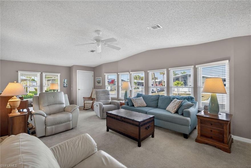 Enter through the front door into a spacious living area featuring a built-in wall unit—perfect for a large screen TV—with cabinets below providing generous storage. The dining area flows seamlessly from the living space and sits conveniently adjacent to the upgraded kitchen, which offers abundant counter space, updated finishes, and a center cooking island with an attached breakfast bar—ideal for casual meals or morning coffee.

Just beyond the kitchen, the family room creates a comfortable secondary living space and leads to the large primary bedroom or second bedroom, both offering ample closet storage. The lanai provides a cozy spot to relax, read, or enjoy your favorite shows, with additional storage located just off the lanai.

Outdoors, mature landscaping and a variety of fruit trees create a peaceful setting, perfect for unwinding in the backyard while enjoying evening sunsets. A separate storage shed located behind the property offers even more space for tools, hobbies, or seasonal items. Laundry facilities are conveniently located inside the home, and ample parking makes hosting guests or accommodating multiple vehicles easy and stress-free.