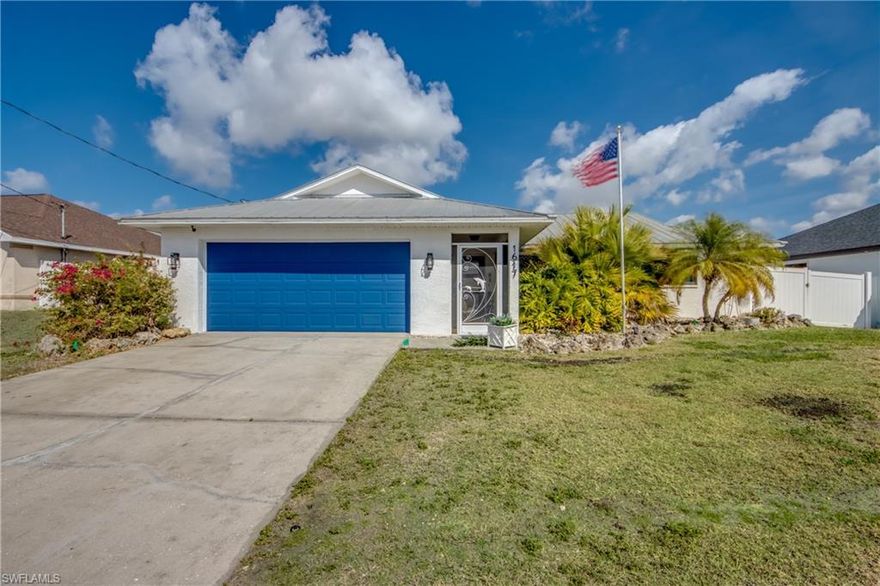 Discover this beautifully maintained home in Southwest Cape Coral, featuring a fully fenced yard and inviting outdoor spaces. Positioned in desirable SW Cape off of Chiquita Blvd and conveniently situated between both bridges to Fort Myers, this home offers access to shopping, dining, schools, parks, beaches, and all that Southwest Florida living has to offer. Ride your bike to Surfside Shops, grab your favorite drink at Starbucks, or meet friends at local favorite Keg & Cow. This home blends comfort, functionality, and location. From the moment you arrive, you’ll notice the mature, lush landscaping and inviting screened front entry with standing seam metal roof detail that adds both charm and durability. A PVC fence surrounds the entire property, creating privacy and security, while the backyard is set up like a private retreat with plenty of room to design your dream outdoor oasis, including space for a pool and expanded entertaining area. The brand new irrigation system comes with a two year warranty. Inside, the split bedroom floor plan maximizes space and provides privacy and flexibility. Tile flows throughout the home and continues into the lanai, while select rooms feature wood laminate flooring for added warmth and style. The dining room features built-in shelving, perfect for a coffee bar or custom display space, and the kitchen is equipped with stainless steel appliances. Impact resistant windows and doors installed in September 2022, offer storm protection and energy efficiency, while the metal roof provides lasting durability. Don’t miss this opportunity to own a piece of paradise in one of the fastest growing areas of Cape Coral.