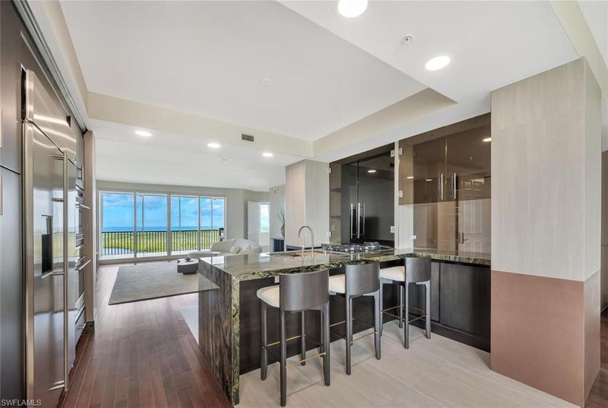 Step into the sky and experience luxury Naples living at its finest. The moment your private elevator doors open, you are met with a stunning panoramic view —Gulf waters stretching endlessly to the horizon, shimmering bay views, and the dramatic glow of the city skyline to the north.    Custom redesigned and remodeled with an contemporary elegant Italian architectural mindset, the home now breathes with openness, clarity, and modern elegance. Walls were reframed, sightlines were opened, and a unified design was woven into every inch of space. With more than 3,000 sq. ft. of refined living, this residence frames panoramic vistas of the Gulf, the bay, and sparkling city lights to the north. The signature Epidus Green quartzite flows throughout like a continuous thread, anchoring the home in natural beauty and creating visual harmony. Polished Brazilian hardwood floors, custom smoked-glass cabinetry, and luminous metallic accents add depth, contrast, and quiet glamour. At the heart of the residence lies a showstopping kitchen—dramatically reshaped to feel expansive and sculptural. The repositioned island invites the eye outward to the views, while balanced cabinetry walls create architectural symmetry. Every detail is refined: push-to-open millwork, Miele appliances, custom blackened wood finishes, and the rare quartzite sourced through Italy’s iconic CITCO, turning the countertops into functional art. Retreat to the primary suite, where a spa-like bath wrapped in stone and soft textures offers total serenity. Italian-made fixtures from WEAREINDUSTRIA, travertine surfaces, herringbone stone floors, and custom metallic finishes create an atmosphere of pure indulgence. The walk-in closet, crafted with warm bespoke finishes, feels like a private boutique. Beyond the residence, the lifestyle is unparalleled. The Grande Phoenician provides exclusive access to its own private pool, spa, and fitness facilities, while the legendary amenities of The Dunes elevate every day—resort-style pool, vibrant tiki bar, championship tennis and pickleball, state-of-the-art fitness, and upscale dining. A coveted membership to The Floridian Club places the ultimate luxury within reach: private beach access, full food and beverage service, and an effortless shuttle from your front door.Perfectly positioned near world-renowned shopping, dining, and Naples’ most iconic beaches, this residence offers a rare blend of design-forward living and resort-level indulgence.This is not simply a home.

It is a masterpiece in the sky—crafted for those who expect beauty, refinement, and a view that steals the breath away.