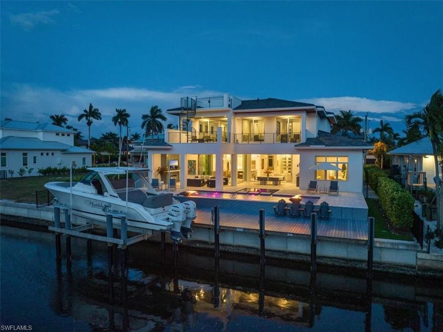 Paradise living in this waterfront community of Royal Harbor.  Welcome to 2130 Snook Drive the epitome of luxury living in an extraordinary boating community near Old Naples and Naples' pristine beaches. This stunning newer home blends casual elegance with thoughtful design, featuring a great room floor plan perfect for entertaining, highlighted by large sliding pocket doors that seamlessly transition to the covered lanai. Culinary enthusiasts will be captivated by the gourmet kitchen, equipped with high-end appliances, a spacious island with seating and storage, and a dining area with a bar and wine storage. The owner's suite is a private sanctuary, offering a seating area, a spa-like en-suite bath, and a custom closet, while a first-floor den overlooks the lushly landscaped front yard. The second-floor hosts three generously sized bedrooms, each with walk-in closets and en-suite baths, along with two loft spaces and a second laundry room. Car enthusiasts will appreciate the three-car garage, complete with epoxy flooring and a car lift for fourth car storage.  Entering from the garage there is a drop zone with bench seating and storage, plus an elevator for easy access to the second floor. Outdoor living is elevated with expansive covered lanai spaces on both the first and second floors, a third-floor observation deck, a summer kitchen, a cozy fireplace, and a pool and spa surrounded by fire pits and ample deck space. Boating enthusiasts will love the composite deck, dock, and boat lift, making waterfront living a dream. This home is truly a masterpiece of indoor and outdoor luxury.