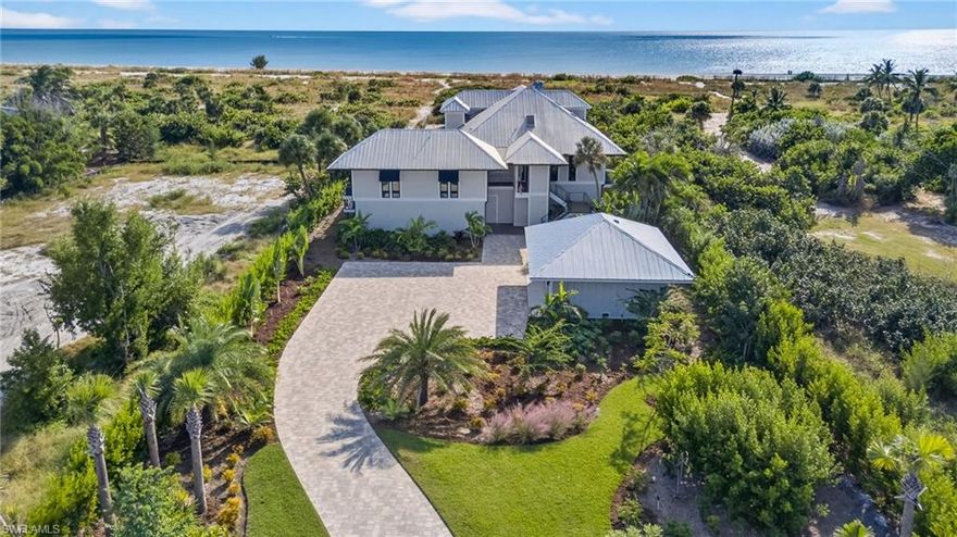 A rare offering on Sanibel’s exclusive Joewood Drive, this completely reimagined Gulf-front estate embodies understated coastal luxury and meticulous craftsmanship. Set within the private Gulf Ridge community, the home has been rebuilt from the ground up, featuring a new standing-seam metal roof, impact-rated glass throughout, and a whole-house generator for complete peace of mind. Designed for effortless island living, the residence offers soaring ceilings, an open-concept layout, and panoramic Gulf views that flood the interiors with natural light. The elevated pool and deck flow seamlessly from the main living level, creating a perfect indoor-outdoor experience for entertaining or quiet reflection. A private path leads from the home to a vast stretch of pristine beach, where shell-covered shores and breathtaking sunsets capture the essence of Sanibel’s natural beauty. Additional highlights include a private elevator, a chef’s kitchen with custom cabinetry and professional-grade appliances, and designer furnishings throughout. A stand-alone two-car garage provides added storage and flexibility for vehicles, golf carts, or beach gear. Every space, surface, and system has been thoughtfully curated for beauty, comfort, and durability. Move-in ready and masterfully rebuilt, 5079 Joewood Drive represents one of Sanibel Island’s finest Gulf-front homes, where refined design meets relaxed island living amid one of Florida’s most extraordinary coastal settings.