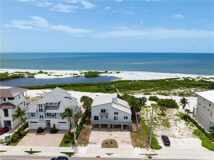 Welcome to your beachfront paradise on the coveted south end of Fort Myers Beach!  This exceptional 3040 sqft, turnkey residence offers a unique opportunity to own a piece of island luxury with unobstructed, 180-degree views of the Gulf of Mexico, all for a price unlike anything else on the market.  Designed for effortless entertaining and coastal living, the desirable open-concept floor plan creates a warm and inviting atmosphere. The standing seam metal roof installed in 2022 gives additional peace of mind.  The chef's dream kitchen is a culinary masterpiece, featuring stainless steel Jean-Air appliances, including a six-burner range with a griddle and double ovens. A pasta arm faucet and a large exhaust hood complete the range area, while a separate island with a sleek prep sink and under-counter mini-fridge provides extra convenience. A huge breakfast bar overlooks the eat-in nook, living with additional wine refrigerator, and dining areas, all framed by breathtaking gulf views.  The massive primary suite is a true retreat, boasting a wet bar and offering the kind of stunning Gulf coast sunsets typically reserved for travel magazines. The spa-like primary bath features dual vanities, marble flooring, a walk-in shower with multiple shower heads, and a separate jetted tub with a seamless, glass-to-glass corner window perfectly positioned to overlook the beach.  The home offers additional luxurious accommodations, including an ensuite bedroom with a sliding glass door opening to a space to re-build the private beach-view balcony, plus two additional ensuite bedrooms that offer private balconies with views of Estero Boulevard. With two laundry areas, this home provides all the comforts and conveniences you desire.  Open the windows and sliding glass doors to feel the inviting Gulf breeze fill the house. An elevator chase is conveniently located near the front of the house. A private path leads you to one of the island's most secluded, white sandy beaches, with pristine, turquoise waters. This versatile property is perfect for a private beachside residence or as a high-income rental investment.  Enjoy the convenience of being close to shopping, dining, public marinas, and the vibrant life of Bonita Springs and Downtown Fort Myers Beach. For added peace of mind, a structural engineer approval letter was obtained after Hurricane Ian, and the publicly available FEMA 50% Rule letter indicates a building value of $1.274 million, leaving ample room for any necessary/desired improvements. Sold fully furnished and as-is, this exceptional opportunity is ready for you to start living your beachside dream.