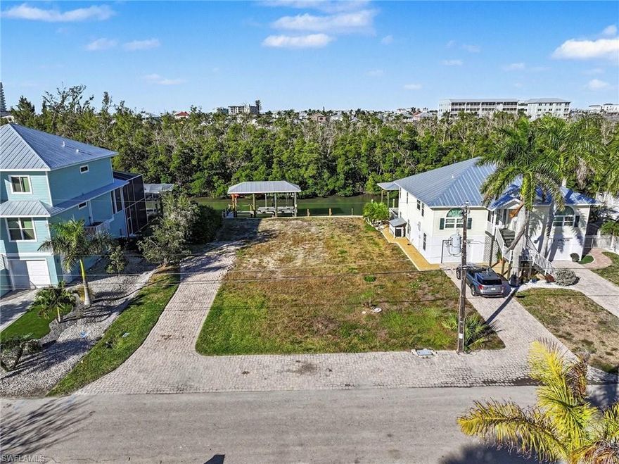 Located at 225 Tropical Shores, Fort Myers Beach, this 71 ft x 108 ft waterfront lot offers canal frontage with quick, direct access to the Gulf of Mexico via the Back Bay. The property includes a covered boat dock with lift, providing immediate boating convenience in a well-established canal setting. Situated on a weekly rental street, the lot allows flexibility for future development, whether as a primary residence, secondary home, or income-producing property (subject to local regulations). Its size and configuration support a variety of building options for a custom home or investment project. The location provides proximity to area beaches, marinas, dining, and entertainment, including Times Square and Margaritaville, while maintaining a canal-front setting ideal for water access and coastal living.This property presents a rare opportunity to build in one of Fort Myers Beach’s desirable boating areas with existing dock infrastructure already in place. Buyer to verify all zoning, building, and rental requirements.