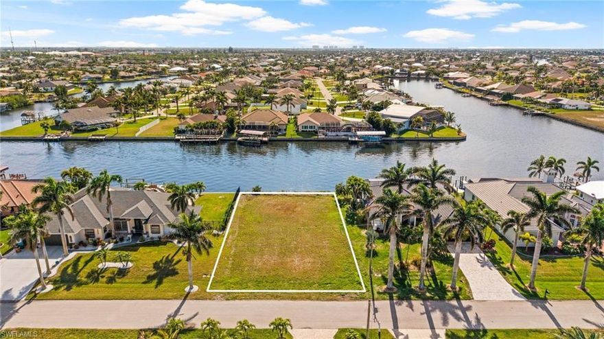 This stunning lot is a rare find, situated on one of the widest canals in Cape Coral, an impressive 200 feet across. GULF ACCESS to Open water. Offering breathtaking views where two canals intersect. With a coveted southern exposure, this property is perfect for soaking in spectacular sunrises and sunsets. A sturdy seawall is already in place, providing the perfect foundation for your waterfront dream home. Nestled in a quiet, established neighborhood with city water and sewer, this prime location is just off Veterans Drive, offering convenient access to the highway system. For boating enthusiasts, this lot provides direct access to the Gulf of Mexico, making it easy to enjoy endless days on the water. Lined with picturesque palm trees, the street creates a truly magical setting. Located near the highly desirable Surfside area, this hard-to-find gem won’t last long. Don’t miss your chance to own a piece of paradise!