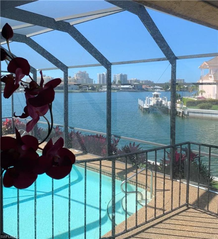 You will be enthralled by the wide water view from the lanai and rear windows of this home.  This one and one half story home boasts 3 large bedrooms each with walk in closets, cathedral ceiling, new roof, 2 zone a/c, large screened in lanai and heated inground pool, lift, dock, davits and fish cleaning station.  The two car garage opens to a full size work room with sliding glass doors opening to the dock area.  All of this is located on a quiet cul de sac for your safety and privacy.