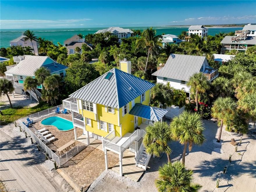 With Fantastic Gulf Views and a Prime Location just 350 feet from the beach, this island-style vacation retreat stands out with its extra charm and character!  Located alongside North Captiva's private airstrip, which gives the home an excellent view corridor.  Great for pilots and beachgoers alike!  Imagine gazing at the water from your living room and sun deck, then relaxing after a day at the beach in your beautiful pool while listening to the sounds of the surf.  Step inside and discover a 2-bedroom, 2.5-bath layout designed for relaxed island living. Top-level painted wood cathedral ceilings give this beachy bungalow a feeling of a much larger home, and with island flair. Abundant natural light pours in through multiple Gulf-facing French doors along the sundeck, truly bringing the outside in for sunset time! The open-concept living and dining area also features a fireplace as a focal point, while the kitchen offers modern cabinetry, solid-surface countertops, and stainless steel appliances. The primary suite includes an en-suite bath with a combined tub & shower, plus direct access to a private balcony for enjoying Gulf breezes. The guest suite is equally inviting, with its own private bath and French doors opening onto the covered screen porch. This hidden gem is a rare combination of proximity to the sugar sand beaches, poolside relaxation, and real island character at an affordable price point!