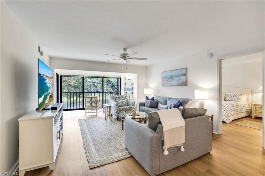 Located in the charming & perfectly located community of Naples Bath & Tennis Club, this lovely coastal-vibe home has been renovated throughout.  Move-in ready, updates in 2022 included quartz kitchen counters, all new stainless appliances, luxury wood-look vinyl plank flooring, new air conditioner and new water heater. More recent improvements include new washer & dryer and all new screening on the enclosed lanai. The well-designed floorplan features two primary en-suite bedrooms, spacious living & dining area, and a sunset facing enclosed lanai with gorgeous private views of tropical foliage, flowering trees and a serene lake -- the lanai offers flexibility, lives like a den, and would also be a great work-from-home space. This PET FRIENDLY community has miles of shaded walking trails through lush mature landscaping. The renowned Sanchez Casal Tennis Academy is located within the Naples Bath & Tennis Club and offers residents hourly tennis and paddle ball court rentals. Practical features include impact resistant storm doors and windows, a conveniently located elevator, assigned convenient parking, large private storage closet just outside the front door. Central to everything that makes Naples a world-class community: pristine Gulf beaches are 4 miles away, Old Naples/5th Ave South and Mercato are less than 15 minutes.