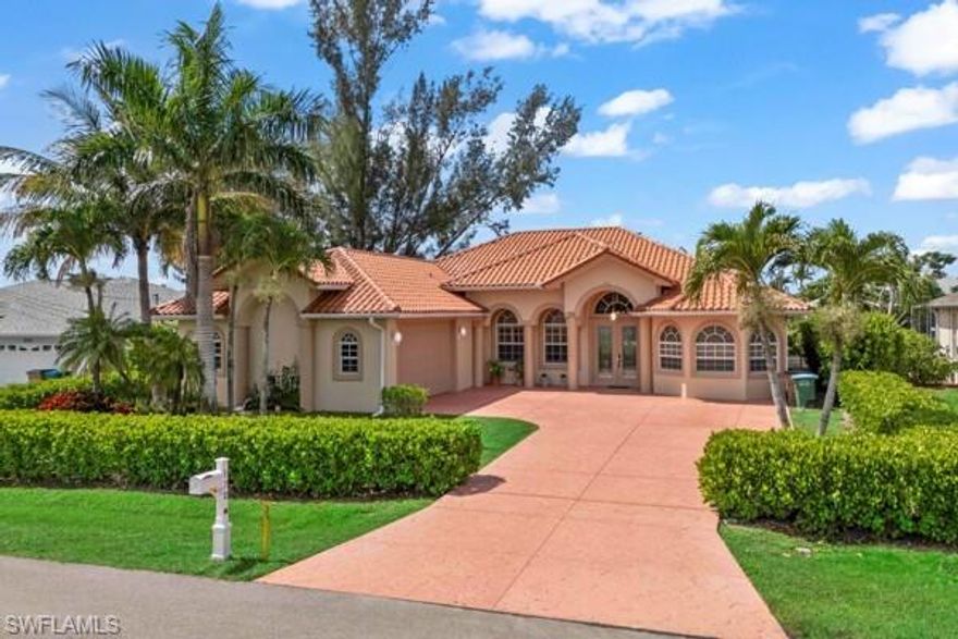 CAPE CORAL FRESHWATER CANAL HOME - This home is located close enough to the intersection of Santa Barbara Blvd and Veterans Pkwy to afford easy access to all the nearby amenities, yet far enough away to allow you to enjoy life on a quiet street with a great neighborhood feel. From the time you pull into the driveway, you will notice the many extras this home offers. There's a beautiful tile roof and hedges surround the lot, affording great green views and privacy. You'll enter through french doors into the living room, which features soaring ceilings above 12-foot walls, and you'll appreciate the wide-open living area, split bedrooms, and multiple dining options. There are great views from everywhere! The home features tile floors and 8-foot solid doors throughout. The doors are all 3 feet wide and will accommodate handicap needs easily. There are impact windows and a tankless water heater.  The air conditioner was replaced in 2019. The primary suite is huge, with a seating area in the bedroom, and a jetted tub and step-in shower in the bathroom. The secondary bedrooms share the other bathroom and afford privacy for your guests. Both the primary and rear secondary bedrooms have sliding door access to the very large screened lanai overlooking the boat dock and canal. A portion of the lanai is under truss. Come see this one - you won't be disappointed!