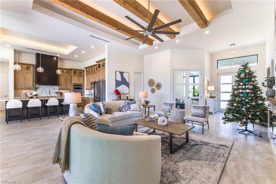 This Direct Gulf access residence blends refined craftsmanship, modern coastal design, and exceptional structural integrity. Thoughtfully engineered with a slab approximately 100% stronger than industry standard, upgraded spray foam insulation, and PGT impact windows, this home was built to exceed expectations for quality and long-term durability.
Positioned on a highly coveted southwest exposure lot, the home enjoys noon-to evening sunlight over the pool, warm winter sun, and exceptional natural light throughout. Zero-corner sliders open to create a seamless transition between the great room and the expansive lanai, capturing the essence of indoor-outdoor Florida living. The covered outdoor living area features a beautifully stained wood ceiling, spacious seating and dining areas, and overlooks a custom heated saltwater pool and raised spa with mosaic tile accents, sun shelf loungers, and wide waterfront views.
Inside, the home offers elevated design at every turn. The great room showcases real cedar beams integrated into an architectural tray ceiling with LED lights showing off their charm, creating a warm and sophisticated focal point. A full custom fireplace wall with herringbone tile surround and wood mantle further anchors the space. The gourmet kitchen features two-tone custom cabinetry, a striking full-height accent hood, level 4 quartz surfaces, designer pendant lighting, built-in oven stack, oversized island with seating for six, and a dedicated glassware and serving station.
The floor plan includes four spacious bedrooms, including a private junior suite, along with a dedicated office with abundant natural light. The primary suite offers a spa-quality bathroom with dual vanities, a freestanding soaking tub, and a large walk-through shower with 6 shower heads, wrapped in dramatic stone-look tile with custom recessed mosaic detailing. Additional features include a large walk-in pantry, an oversized three-car garage (extra depth for your truck), premium large format tile flooring throughout, and a professionally designed landscape package featuring mature palms, layered plantings, and stone beds for an established and polished exterior presence.
With direct Gulf access, premium materials, exceptional craftsmanship, and a setting that embraces the best of Southwest Florida’s waterfront lifestyle, the Ordell stands out as a rare offering for discerning buyers seeking both beauty and longevity in a custom-built home.