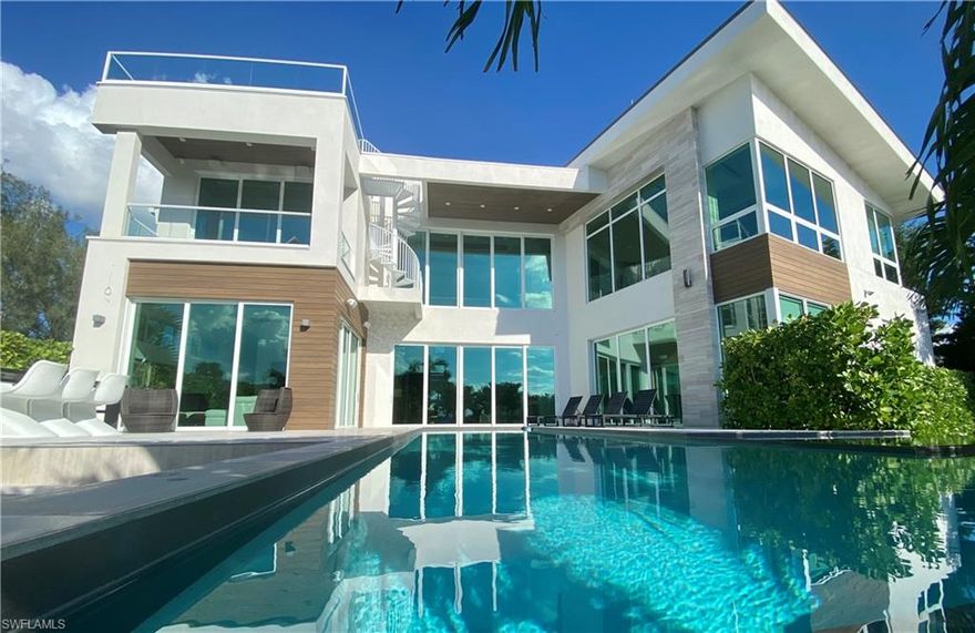 Surrounded by glistening water on two sides, this masterpiece home was designed by renowned modern architect Brandt Henning at HLevel Architecture and built by Seacoast Construction. Beautifully designed with soaring volume ceilings and huge walls of glass overlooking the lap pool, spa and waters of Clam Pass. This four-bedroom, two-office/den gym home with over 6,200 total square feet produces an amazing wow factor from every room, offering a bright, open floor plan highlighting extensive custom detailing throughout. Also featured is an exterior spiral staircase leading to a rooftop terrace with panoramic views of the Gulf, bay and surrounding Naples, making the home ideal to entertain family and friends. Additional features include natural gas, 4KW generator and volume two-car garage, allowing for an addition of lifts to accommodate four cars. Seagate offers easy beach access and its optional resident's membership to their own private and gated Seagate Beach Pavilion. The home is located minutes away from Waterside Shops, luxury shopping, dining and entertainment.