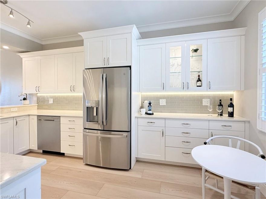 Welcome to this beautifully renovated condo in Naples Heritage Golf and Country Club! Property comes with full golf membership!  Having been totally renovated condo is a rare find.  This beautiful 2 bedroom, 2 bath retreat is ready for new owners to move in and immediately start enjoying the Naples Heritage lifestyle.  Once in the front door you will immediately notice the upgraded luxury vinyl plank flooring that flows throughout the entire condo for a cohesive and clean look.  Heavy baseboards, crown molding, plantation shutters, new high end ceiling fans, custom lighting and fresh paint add to the "like new" feel.  Very tastefully furnished.  The renovated kitchen boasts high end custom-built shaker cabinetry, newer stainless steel appliances, glass tile black splash, under cabinet lighting  and quartz countertops.  Custom cabinetry offers plenty of storage and features pull out drawers and soft close doors.  Eat in kitchen with beverage bar extends kitchen and adds charm.  Dining room in open to living room where sliders open to back lanai.  Condo has spacious primary bedroom with two walk in closets.  Primary bath with floating vanity, backlit mirror with built in defogger, newer comfort height toilet, linen closet, spa like shower with floor to ceiling tile, corner seat and nook. Glass shoer wall and frameless glass shower door.  For added privacy primary and guest bedrooms are split floor plan.  Guest bath with floating vanity, backlit mirror with built in defogger and newer comfort height toilet.  Back lanai is the perfect place relax and enjoy gorgeous sunsets.  View is of water, golf and preserve. Located in the premier bundled golf community of Naples Heritage which is situated on 550 acres of pristine lakes & preserves. Members enjoy an abundance of amenities that include: 18 hole golf course, putting green, pitching green, driving range, resort style pool with cabana bar and grill, fitness center, tennis pavilion, pickleball courts & bocce. Clubhouse hosts both indoor and outdoor dining options as well as a golf pro shop.  Just minutes from downtown Naples and beaches.