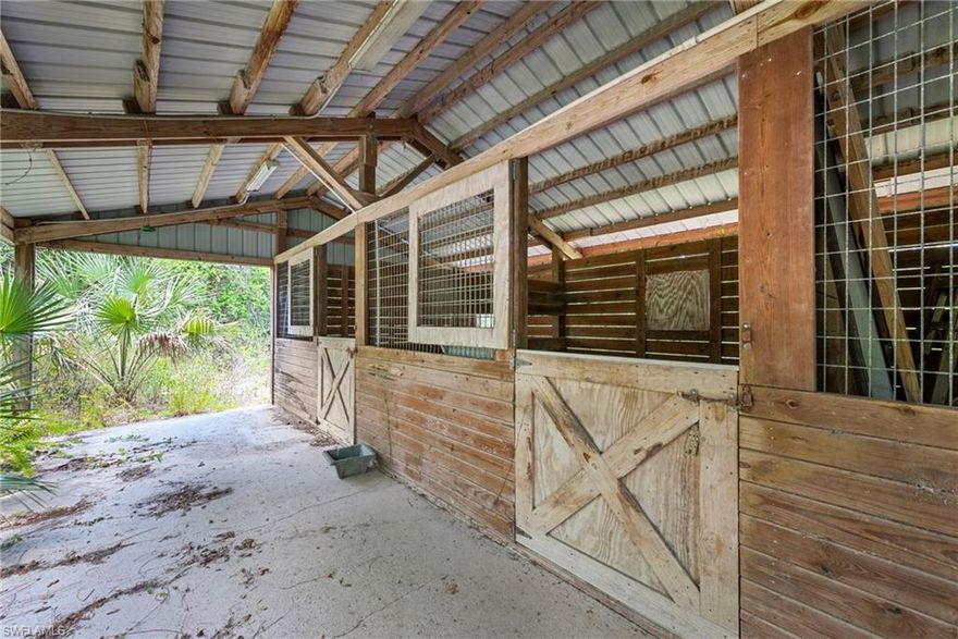 Calling all horse enthusiasts and investors—this is a value-driven opportunity in Golden Gate Estates. Set on over two acres with no HOA, no fees, and no rental or use restrictions, this property offers the freedom to live, work, and build as you choose. The turnout-ready setup features a 60 by 22 stable with three stalls, feed, tack, and wash areas, well suited for personal horses, lessons, or light boarding. The 3 bedroom, 2 bath home offers over 1,700 square feet and a newer roof (2017), but is otherwise in original condition and ready for renovation, offering a clear opportunity to update or reimagine entirely. Whether for a private homestead, hobby farm, or income-producing property, this is a rare chance to secure land, infrastructure, and flexibility in one of Naples’ most versatile non-HOA locations.
