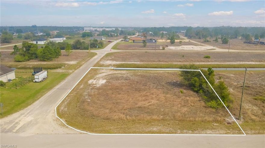 Beautiful CORNER LOT on the water—Oversized 1/4 ACRE—in the sought-after area close to Bell Blvd and SR-82 in Lehigh Acres with many new construction homes in the area! Ideal for you to build your dream home! Located in Flood Zone X which means NO flood insurance required by a lender when you build.