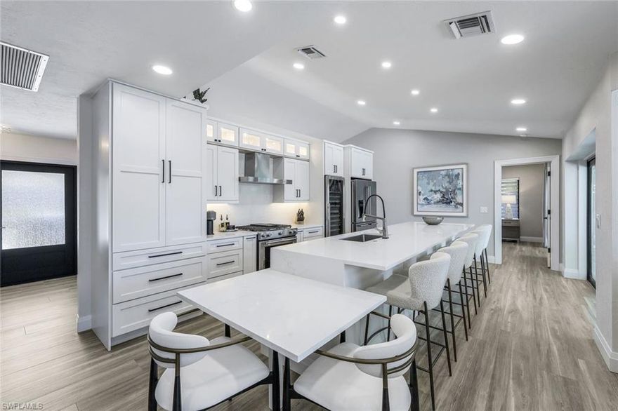 Experience modern coastal living at its finest! This extensively renovated and redesigned 3-bedroom, 2.5-bath pool home boasts meticulous upgrades and thoughtful details. Enjoy peace of mind with all new permitted electrical, plumbing, and impact-resistant windows and doors. Take pleasure in the convenience of a New seawall and dock complete with water and a 16,000 lb boat lift – perfect for waterfront adventures! Inside, discover a beautifully reimagined space with LED lighting, water filtration, and even an acoustic wall for enhanced living. The primary suite is a dream, offering custom closets, a luxurious walk-in shower, private water closet, and dual vanity with automated lighting. Entertaining is a breeze in the gourmet kitchen featuring quartz counters, KitchenAid appliances (including a gas stove), a wine cooler, a 5-seat bar, touchless faucet, and a wet bar with lanai access. Additional highlights include new bathrooms with quartz counters, a solar-heated pool, a 2017 roof, AC garage with new hurricane rated door, mini-split and storage, fruit trees, extra insulation, new PEX plumbing, new sewer lines,  handicap accessibility, and desirable southwest exposure. Even the yard boasts meticulous touches like a French drain system and an outdoor shower. Plus, enjoy limitless hot water with the tankless on-demand system.