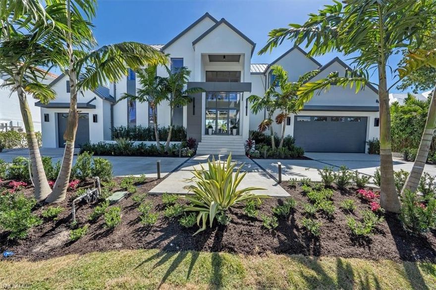 This newly built waterfront home by Oakley Home Builders with direct Gulf access & smart home automation is a boater & car collector's dream! The 2-story design masterpiece exudes contemporary elegance with hardwood & marble tile floors allowing for a seamless connection between the 5,800-sf indoor & expansive outdoor living spaces. The stunning floor plan presents a double height foyer leading to the Great Room, with paneled ceiling, welcoming fireplace wall & custom cabinetry. The gourmet kitchen with top-of-the-line appliances showcases a custom cabinets, grand center island, double ovens, comfortable dining space, & butler's pantry. The first floor ensuite master bedroom has  pocketing doors leading to the pool deck, spa-like bath with separate soaking tub, & dual vanity sinks. The private elevator whisks guests to the 2nd floor with 4 ensuite bedrooms, living area, and balcony access. Outdoor amenities include a summer kitchen with gas grill, fire pit, sparkling pool & spa. Car aficionados will love the 3 garage spaces, with options for lifts totaling 6 cars. A short stroll to Naples beaches & 3rd St. South, this home has been beautifully furnished by Clive Daniel.