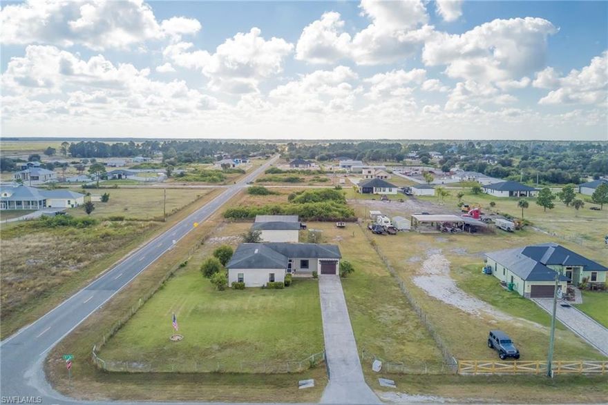 Discover this beautiful 1.25-acre property in a quiet area of LaBelle, featuring a spacious 4-bedroom, 2-bathroom home with an inviting open floor plan. The large kitchen is perfect for entertaining, complete with a generous island and plenty of counter space and accented by two charming barn doors that enhance the home’s country feel. Ceramic wood-plank tile flooring runs throughout, adding both style and durability. The primary suite offers a double-sink vanity and a walk-in shower. Practical updates include a roof and A/C unit that are only 6 years old. Outside, enjoy a fully fenced property with a yard irrigation system, a 1-car attached garage, a 30x40 detached 2-car garage, and a 30x30 carport—ideal for vehicles, storage, or hobbies. With no HOA, you’ll have the freedom to truly enjoy your space. This property blends comfort, functionality, and peaceful living—don’t miss the chance to make it yours!