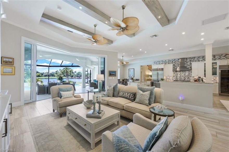 A Trifecta of Location, Design and Immediate Golf! At this private cul-de-sac estate, breathtaking lake and fairway views are topped off by westerly sunsets on the horizon. The tranquil oasis in the Audubon Signature Sanctuary of Collier's Reserve fuses location with the remastered sophistication of a gut-remodeled four-bedroom/four-and-one-half-bath residence; a den/office plus a large den/media room with wet bar make this luxury home a remarkable find. The light-filled Great Room flow is enhanced by soaring ceilings and ten-foot tall telescoping sliding glass doors seamlessly connecting the indoors with the covered lanai and sun-bathed pool deck. The open-concept design draws your gaze to the infinity-edge saltwater pool and the expanse of the lake beyond, all framed by the fairway of hole #7. The heart of the home is the double-island Chef's Kitchen featuring "Taj Mahal" quartzite-topped custom wood cabinetry and top-of-the-line appliances including a Wolf gas range and 200-bottle SubZero wine refrigerator. Outdoors, the poolside kitchen, fully equipped with BBQ, beverage center, ice maker and sink, enhances the expansive lanai complete with wall-mounted TV. “Dreamy” best describes the exquisite Owner’s Suite with a modern spa-like bath including a multi-head walk-in shower and bathtub as well as custom-fitted walk-in and European-style wardrobes. Three additional bedroom suites, spacious and custom-fitted alike, all afford private baths. Finest finishes from wood-look porcelain tile flooring throughout and a leathered marble lanai deck to tasteful designer chandeliers and wall scones are complemented by state-of-the-art smart home technology and highest quality construction specifications from impact-resistant windows and doors throughout and a tile re-roof to a 500-gallon in-ground propane tank and whole-house generator. The circular driveway leading to the air-conditioned three-car garage is the icing on the cake. Don't miss this one-of-a-kind opportunity at Collier’s Reserve Country Club, Arthur Hills’ eco-friendly paradise!