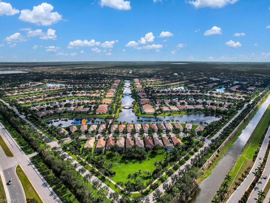 Ready for quick occupancy - this light and bright home with a scenic view of the lake and pedestrian bridge in the much sought after Village Walk of Bonita Springs, a gated resort style tennis community is ready for you! The popular Pine Spring floor plan features rich hardwood floors with 5” baseboards, crown molding, 8’ tall doors, white kitchen cabinetry with granite countertops, a 2 car attached garage, complete surge protection and electric remote control storm shutters. Enjoy watching the sun rise across the water from the extended screen enclosed lanai or the eat-in breakfast area. The primary suite includes a large closet, dual sinks and seamless shower.  The Town Center with numerous amenities including a gas station, touchless car wash, tennis, pickleball, basketball and bocce courts, playground, world class fitness center, restaurant, bagel shop, hair salon, spa and full time lifestyle director! Lawn maintenance, irrigation, internet and cable TV are all provided by the HOA. Located just minutes from Naples, Fort Myers, beautiful beaches, world-class shopping, International Airport, parks, dining, museums, galleries and entertainment! Ask about special financing options!