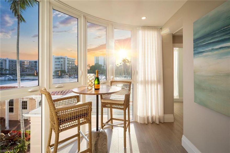 Sunrise over Venetian Bay and sunset over the Gulf, experience both from this beautifully reimagined coastal retreat at Venetian Villas in Park Shore. Located on the second floor and offering 2,479 total square feet of thoughtfully designed single-level living, this residence blends bespoke craftsmanship with relaxed coastal elegance. A private elevator opens directly into light-filled interiors featuring wide-plank tile flooring both elegant and pet friendly enhancing the home's sophisticated yet comfortable coastal aesthetic and refined finishes throughout. The elevated living space provides added peace of mind, with approximately 95% of the residence unaffected during past storms.
The expansive great room flows seamlessly into the formal dining area, creating an inviting space for both everyday living and effortless entertaining. At the heart of the home, the gourmet kitchen showcases a striking stone-wrapped island, premium appliances, wine storage, and exceptional design that balances beauty and functionality.
The well-designed floor plan offers three spacious ensuite bedrooms plus a powder room, providing privacy and comfort for both residents and guests.  Additional features include a tucked away laundry area, custom finishes, soft drapes, privacy shades, and a private garage for one car.  
The spacious balcony, with motorized awning, is ideal for enjoying coffee while taking in the bay breezes and wide water views.  Watch stunning sunsets through the home's unique curved windows that look out over the marina and toward the Gulf.  Just across the street, residents enjoy direct beach access along the Gulf, including private Park Shore beach privileges, making it easy to start the day with a peaceful walk along the shoreline or an energizing morning stroll along the scenic beachfront paths, a favorite daily ritual among neighbors. Venetian Villas offers a bayside pool, secure entry, excellent onsite management, and potential boat dock availability.  An exceptional opportunity to experience luxury, panoramic water views, beach access, and effortless coastal living in one of Naples' most desirable waterfront locations.