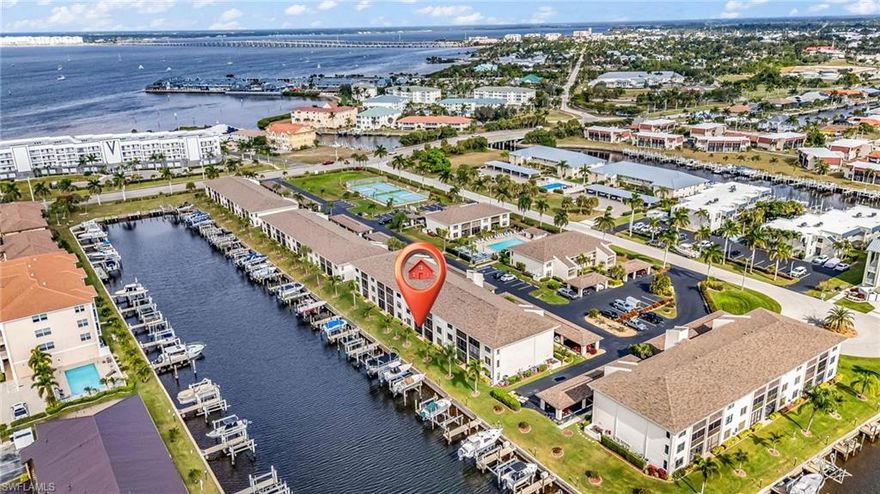 Just steps from your screened lanai to your private dock and boat lift, this furnished, turnkey 2-bedroom, 2-bath ground-floor waterfront condo delivers the easy Florida lifestyle—plus QUICK, DIRECT ACCESS TO CHARLOTTE HARBOR in under 5 minutes by boat. Located in highly sought-after Bridge Point Condominiums in Punta Gorda Isles, this well-maintained community is prized for its waterfront setting, upkeep, and resort-style amenities. Inside, you’ll appreciate the rich wood kitchen cabinetry, stainless steel appliances, and a smart layout designed for everyday comfort, leisure, and entertaining. The open dining and living areas capture beautiful canal views, and the spacious primary suite enjoys gorgeous southwestern exposure for unforgettable sunsets. The primary includes a walk-in closet and an updated en-suite bath featuring dual sinks, matching wood vanity, and a tiled walk-in shower. A split-bedroom floor plan provides privacy for guests, with the second bedroom, full guest bath (tub/shower combo), and interior laundry room located on the opposite side of the home. Recent updates include NEW BOAT LIFT MOTOR and NEW AIR CONDITIONER, both in 2025. Community amenities include a heated pool, pickleball courts, recreation area, and convenient poolside restrooms/changing space. You’ll also enjoy reserved parking plus ample guest parking. Take a walk or bike ride to Fishermen’s Village or historic downtown Punta Gorda with its waterfront dining, boutique shops, and year-round festivals. The Isles Yacht Club, St. Andrews Golf Club, and Ponce and Gilchrist Parks are all just minutes away. Whether you’re boating, fishing, golfing, biking the 18+ miles of nearby trails, or playing pickleball, you’ll fall in love with Punta Gorda’s charm, sunshine, and friendly community. Punta Gorda Airport (PGD) is approximately 15 minutes away, offering non-stop flights to over 65 destinations — getting here is as easy as living here. This waterfront gem has been lovingly maintained and is priced to sell. Come see why so many people fall in love with Punta Gorda Isles — schedule your private showing today! CHECK OUT THE VIRTUAL TOUR FOR A PROPERTY WALK-THROUGH.