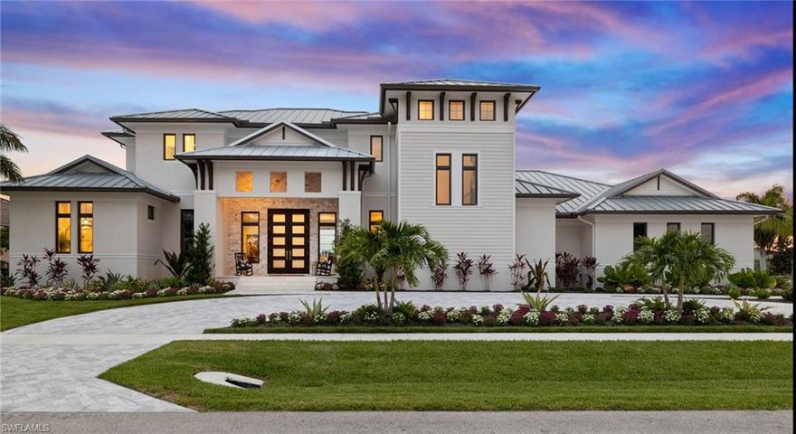 Available for the first time, this recently completed Coastal Organic Transitional masterpiece redefines refined island living. Perfectly positioned on a coveted oversized shoulder lot with rare dual-street access, the home enjoys 270-degree western exposure and sweeping, ever-changing views of Marco Island's magnificent coastal skyline.

Spanning approximately 4,700 square feet, this newly constructed estate delivers exceptional scale, abundant natural light, and a timeless architectural presence. A dramatic open-plan entry immediately draws the eye through expansive walls of 10-foot hurricane-impact retractable glass sliders, seamlessly dissolving the boundary between indoors and out. The horizon becomes part of the home—framed by a striking glass-tile pool with shell-stone stepping features, flowing effortlessly to an infinity-edge spa. Surrounded by lush, custom landscaping, the setting is a private coastal sanctuary.

The residence offers five en-suite bedrooms, a dedicated office, and six spa-inspired baths, thoughtfully designed for both elegance and comfort. Additional highlights include a full laundry room designed for sandy toes, a modern elevator, and a generous second-floor living area with sunset terrace, ideal for evening gatherings and golden-hour views.

Outdoor living is equally exceptional, featuring a resort-style pool and spa, outdoor kitchen with bar and dining area, and a convenient outdoor shower—perfect for long, breezy afternoons. A three-car garage includes potential separate guest or private quarters, enhancing flexibility and privacy. The home is crowned with a durable metal roof and equipped with a Tesla charging station, blending luxury with forward-thinking functionality.

Inside, European white oak wide-plank flooring flows throughout, setting a warm, organic tone. The chef's gourmet kitchen is outfitted with top-of-the-line appliances and anchored by a custom-designed wine showcase that commands attention and elevates entertaining. The primary suite is a true retreat, complete with a spa-level bath and expansive walk-in shower, delivering a daily resort experience.

This custom home reflects a natural, organic foundation—where stone, texture, coastal hues, and curated seaside photography tell a distinctive story. Every detail is intentional, beautifully choreographed to capture a fresh, modern coastal rhythm of life.