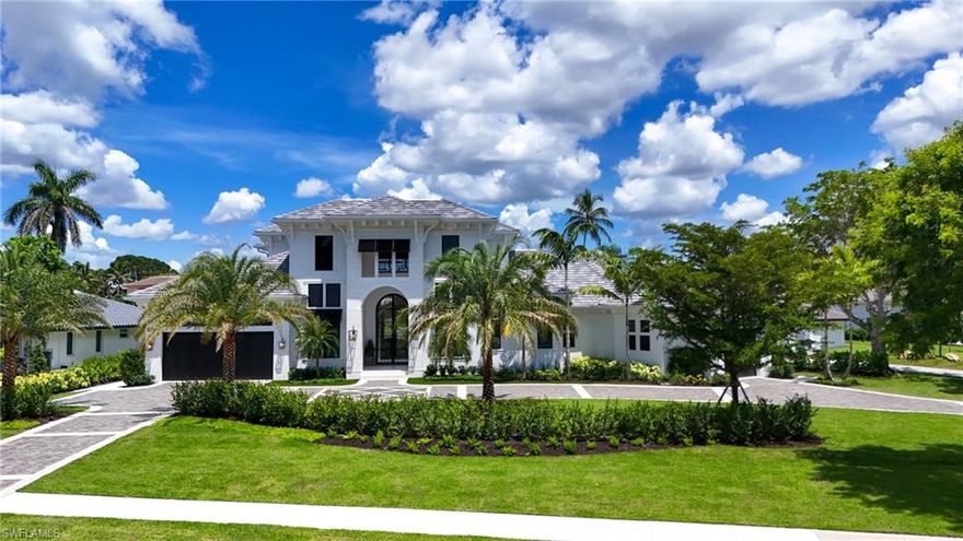 Experience unparalleled lakefront living on coveted Devils Lake in Park Shore, just a 10-minute stroll to Naples’ white sand beaches. Just completed by Borelli Construction of Naples, interiors by R & Co. Designs and furnished by Clive Daniel Home, this impressive 5-bedroom, 5 full and 3 half-bath home (one bedroom easily doubles as a private office) offers a perfect balance of elegance and livability. The open floor plan features a grand 15-foot iron entry door, soaring ceilings, and upgraded European white oak flooring with extensive wood trim and tall baseboards. Natural light pours through 10-foot sliders, framing beautiful water views. A chef’s dream, the kitchen boasts Wolf and Sub-Zero appliances, a butler’s kitchen, and a temperature-controlled wine room with stone accents. Downstairs, the primary suite is a private retreat with a spa-like bath, dual water closets, and a custom LED-lit closet with electric drop-down hanging racks. Two additional bedrooms are located on the main level, while upstairs offers two en-suite bedrooms, a large loft with wet bar, and access to a spacious balcony—complete with seating and a foosball table. Outdoor living is a breeze with multiple entertaining spaces, including a large pool deck with fire pit overlooking the lake. The home’s palatial curb appeal, prime location, and refined finishes make it a rare find in Park Shore. Upgraded features include a whole house generator with 1,000 gallon propane tank, all concrete block exterior walls, Samsung Frame TVs, and Crestron Home and Lutron Lighting automation that controls the hardwired shades, built-in speakers, security cameras and more.