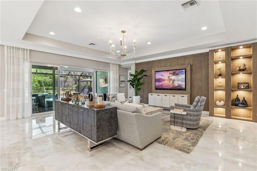 Welcome to an exquisite "Sanibel" model in the highly coveted Valencia Trails community of Naples.  This 3-bedroom plus den, 3-bathroom stunning home features a thoughtfully crafted open floor plan, soaring ceilings, and custom luxury finishes throughout with no carpeting in sight, offered furnished and ready for immediate enjoyment!  The chef inspired kitchen stuns with quartz countertops, a massive entertaining island, stainless steel appliances including a gas cooktop, wall oven, a wine refrigerator, and top of the line cabinetry tailored for both beauty and functionality.  The spa-like owner's suite is your private sanctuary, offering dual vanities, a soaking tub, an impressive glass walk-in shower, and exceptional natural light.  Curated interiors are furnished with pieces from Robb & Stucky and Clive Daniel, elevating each room with comfort and style.  Step outside to your private oasis featuring an extended screened lanai, fully equipped summer kitchen, and a sparkling saltwater pool and spa, perfect for relaxing or entertaining.  Included are storm smart hurricane screens.  Living in Valencia Trails means world-class amenities at your doorstep: a 43,000 sq ft clubhouse, resort-style and lap pools, shaded cabanas, a poolside restaurant and bar, state-of-the-art fitness center, and courts for tennis, pickleball, and bocce.  Scenic walking and biking trails meander through lush, tropical landscaping for the ultimate in active adult living.  don't miss this rare opportunity to own a move-in ready, furnished, luxury retreat in one of Naples' premier active lifestyle communities.